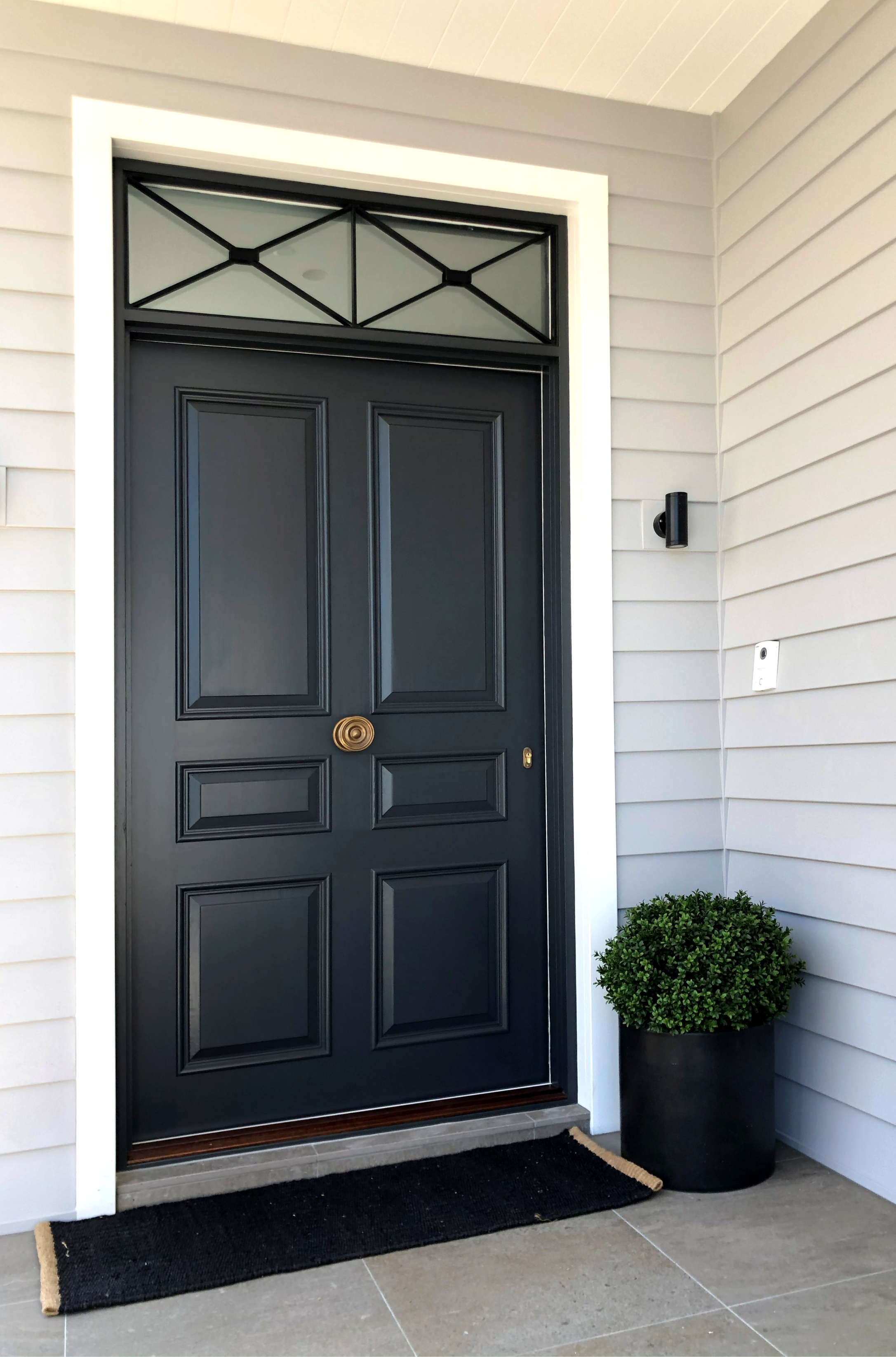 Custom timber panel door with ornate transom window above