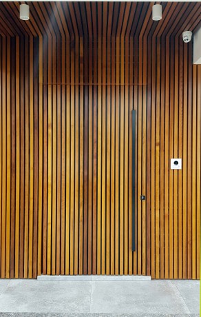 Custom timber door surrounded by Flutestyle Cedar West